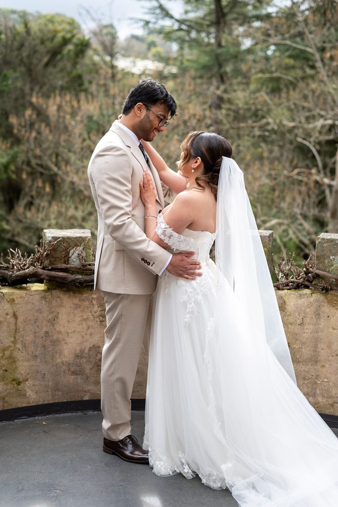 Bride and groom embracing at The Manor balcony