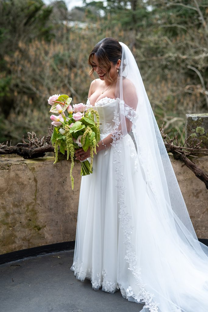 Bride holding her bouquet at the Manor on the blacony