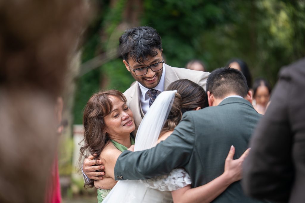Bride and Groom hugging the family