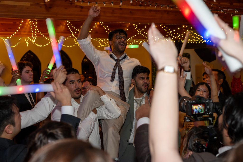 Groom being lifted in the air by the groomsmen at the wedding reception